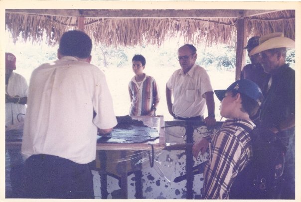 Foto antigua de un grupo de hombres bajo un kiosko de palma