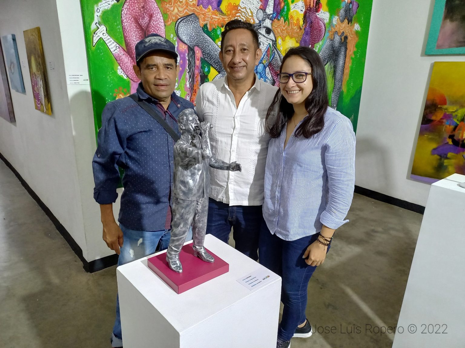 Tres personas posando en una sala de arte