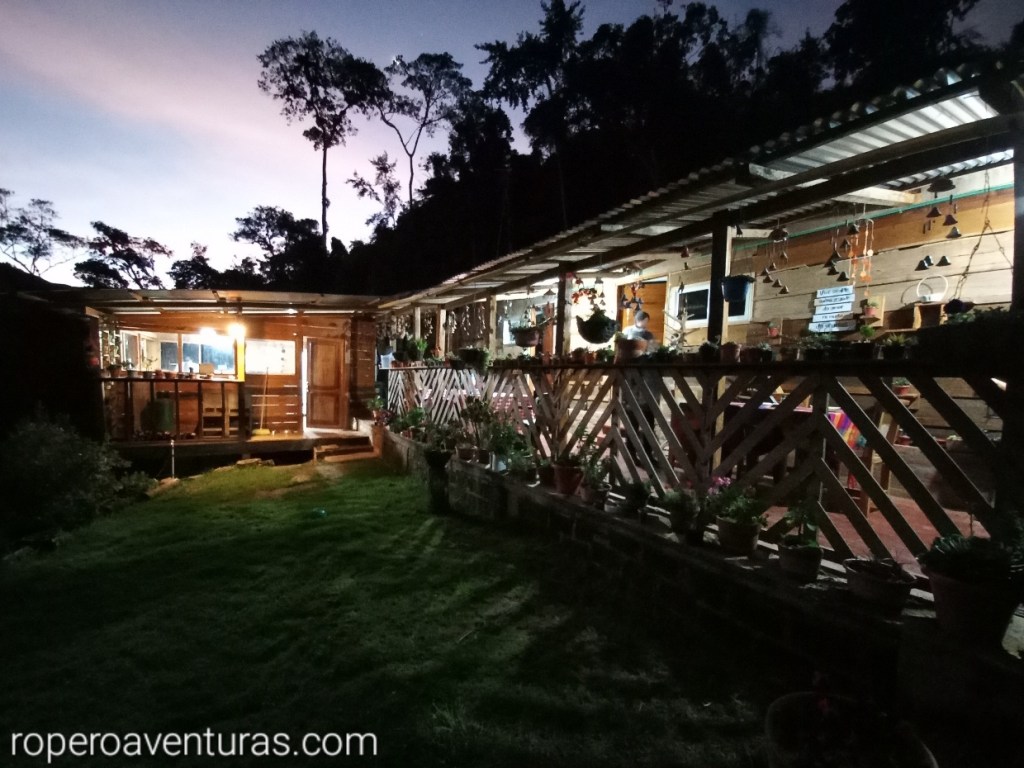 Cabaña de madera en la montaña al atardecer.