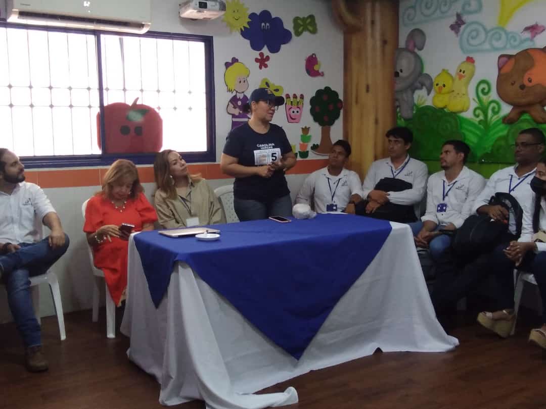 Mujer habla a un grupo de personas en torno a ella