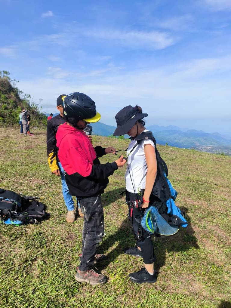 Piloto de parapente preparando a su pasajero